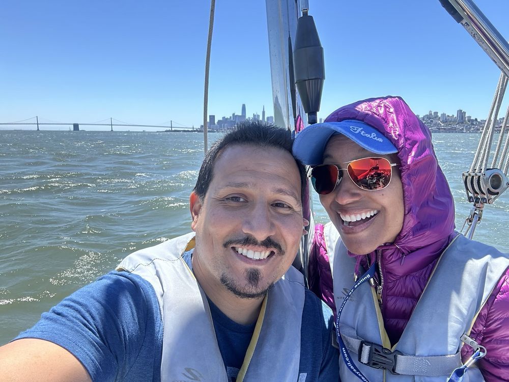 Two guests on deck with the San Francisco waterfront behind them